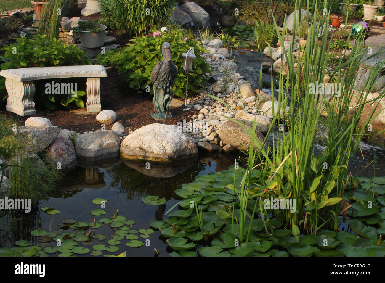 Friedliche Gartenbank. Szene aus einem Hinterhof-Wassergarten in Beavercreek, Dayton, Ohio, USA. Stockfoto