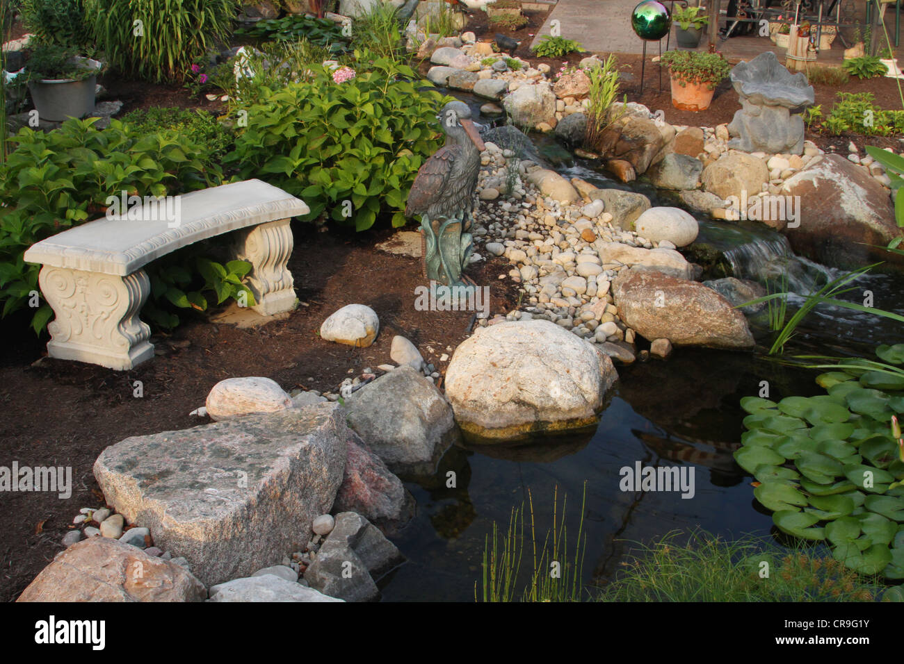 Friedliche Gartenbank. Szene aus einem Hinterhof-Wassergarten in Beavercreek, Dayton, Ohio, USA. Stockfoto