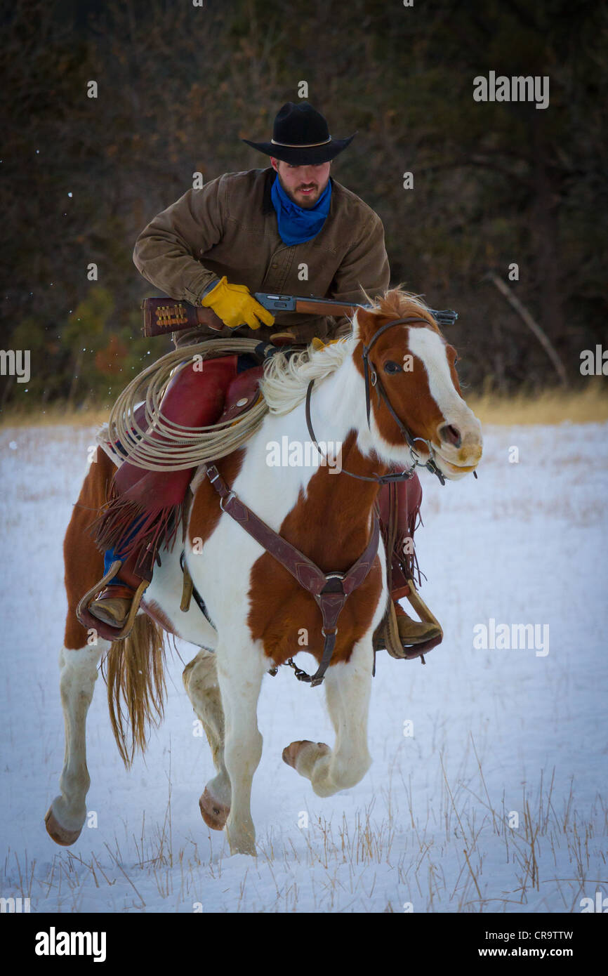 Cowboy und sein Pferd Reiten durch den Schnee auf einer Ranch im nordöstlichen Wyoming Stockfoto