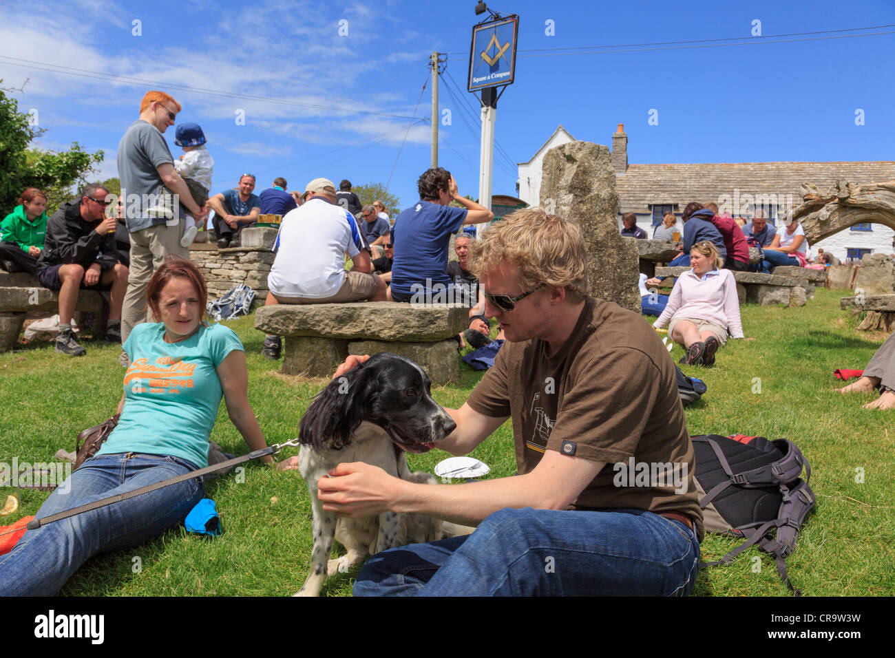 Authentische Szene mit Kunden sitzen in belebten Biergarten von Square und Compass Country Village Pub Lifestyle. Worth Matravers Purbeck Dorset UK Stockfoto