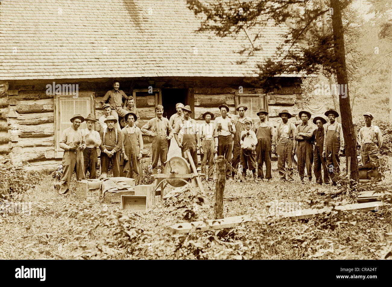 Große Gruppe von Arbeitern vor Blockhütte Stockfoto