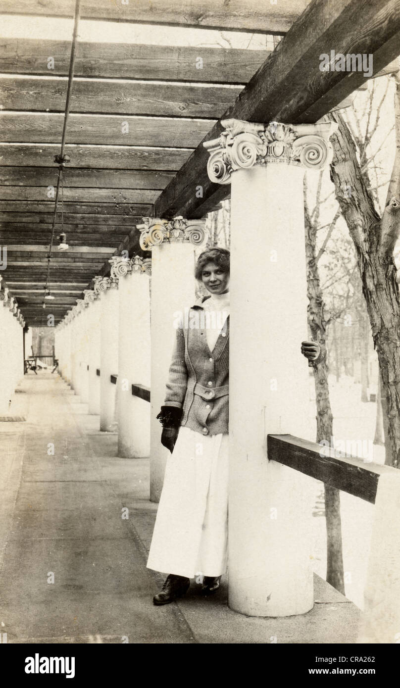 Junge Frau in einer Kolonnaden Pergola Stockfoto