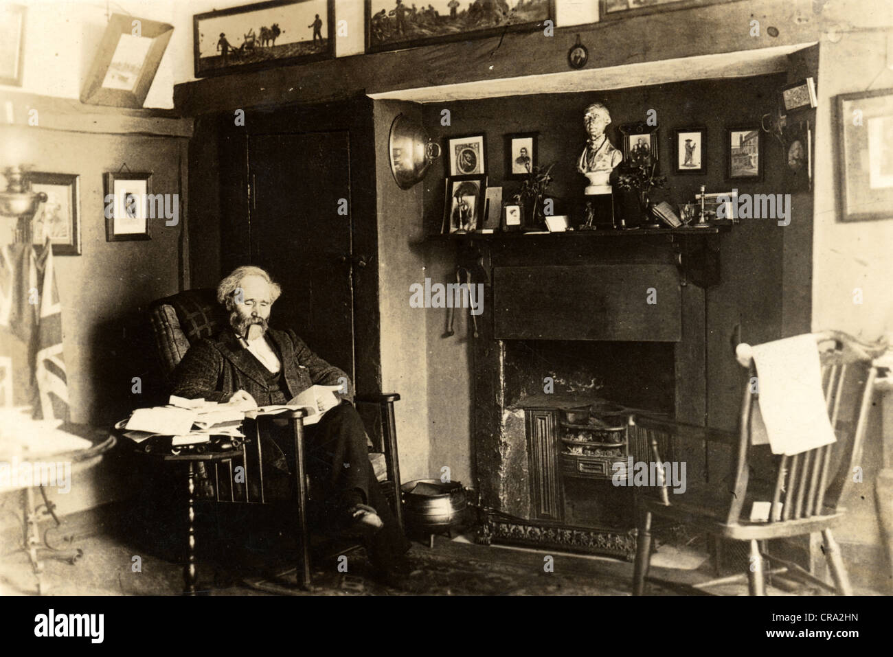 Im Alter von britischen Gelehrten Lesung im Salon vor Kamin Stockfoto