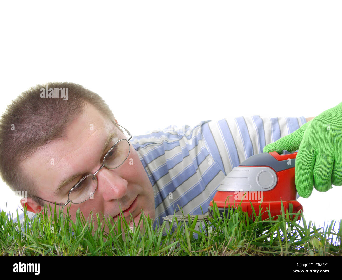Junger Mann trimmen frische Gräser mit trimmer Stockfoto