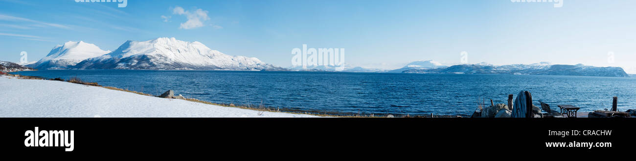 Große Bucht außerhalb Bakkejord, Norwegen, mit schneebedeckten Bergen im Hintergrund Stockfoto