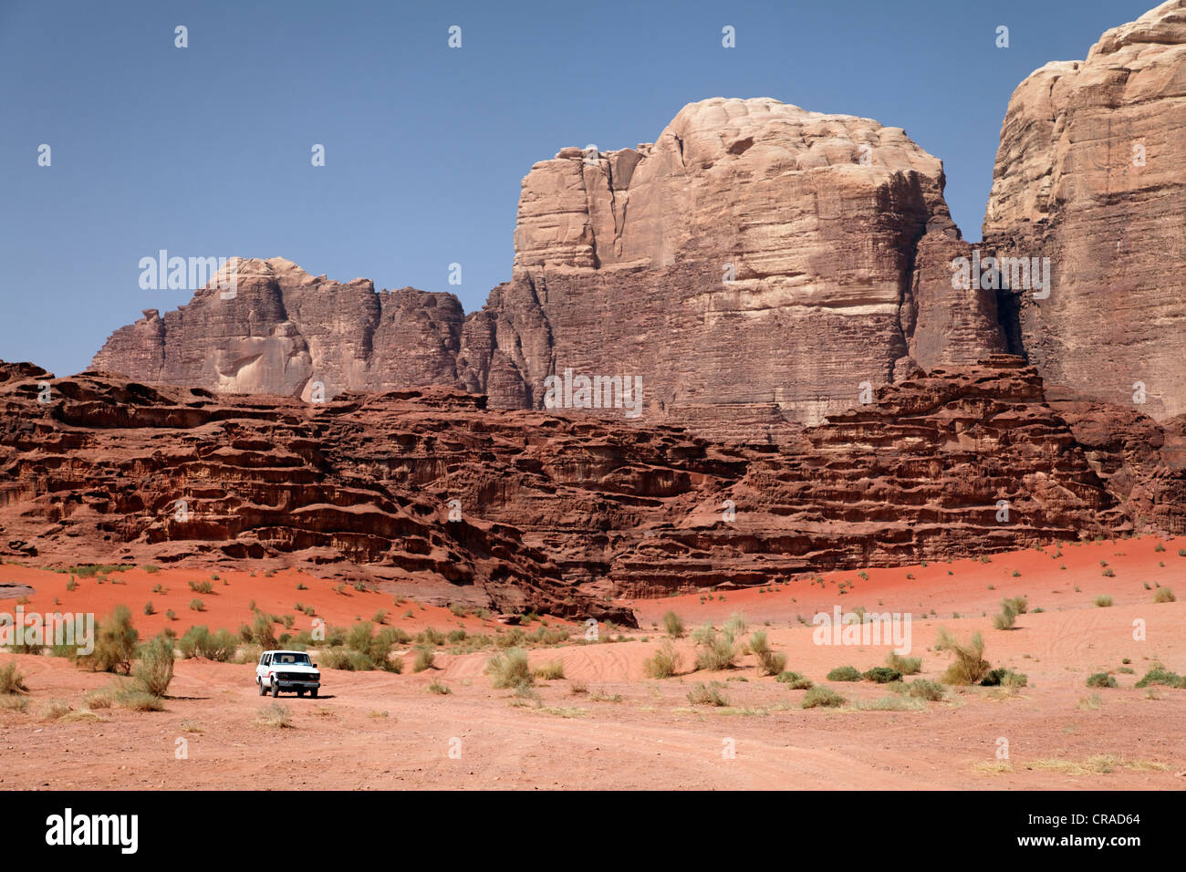 Off-Road-Fahrzeug vor Bergen, weiten Ebenen und roter Sand in der Wüste, Wadi Rum, Haschemitischen Königreich Jordanien Stockfoto