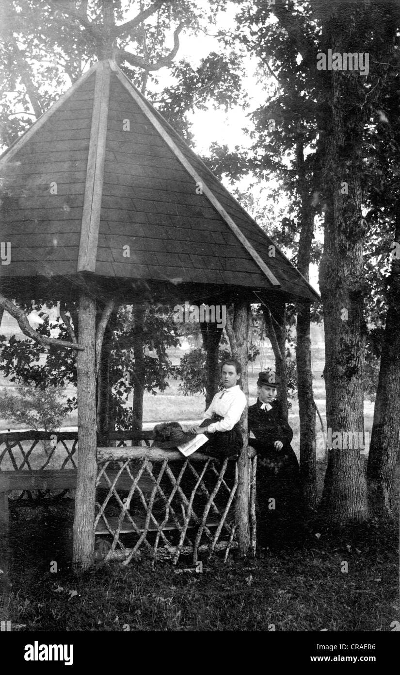 Zwei viktorianische Mädchen am rustikalen Pavillon Stockfoto