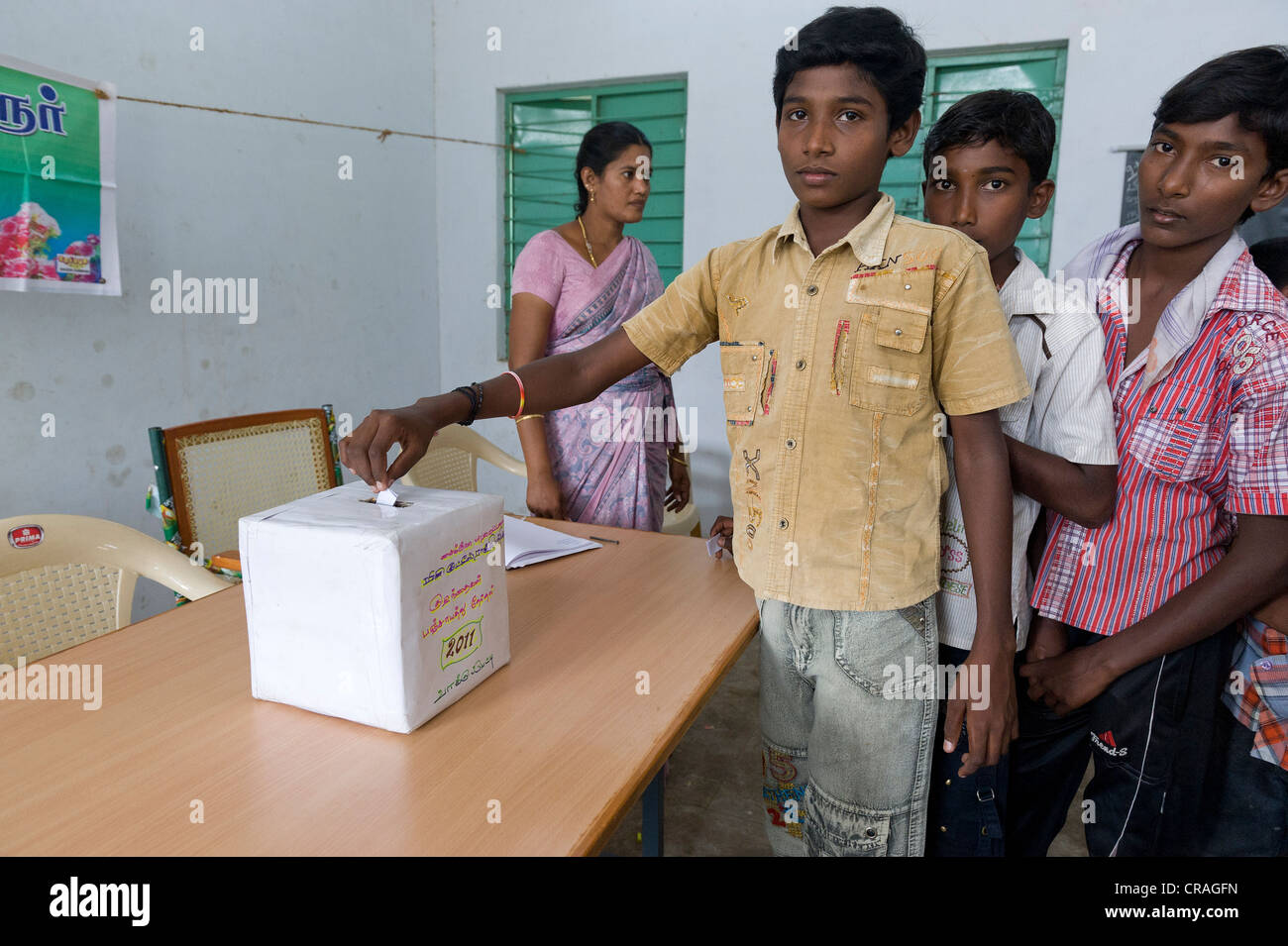 Jungen setzen Stimmzettel in die Abstimmung Box, Mini Kutties Rajiyam, Panchayat Wahlen, Noyyal Maravapalayam in der Nähe von Karur, Tamil Nadu Stockfoto