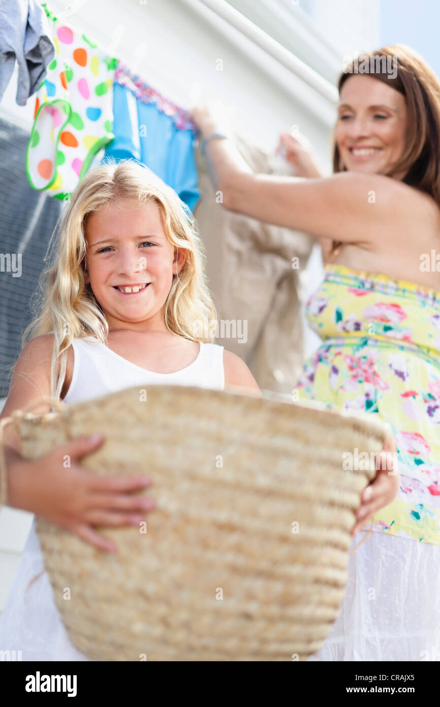 Mädchen helfen Mutter hängen Wäsche Stockfoto
