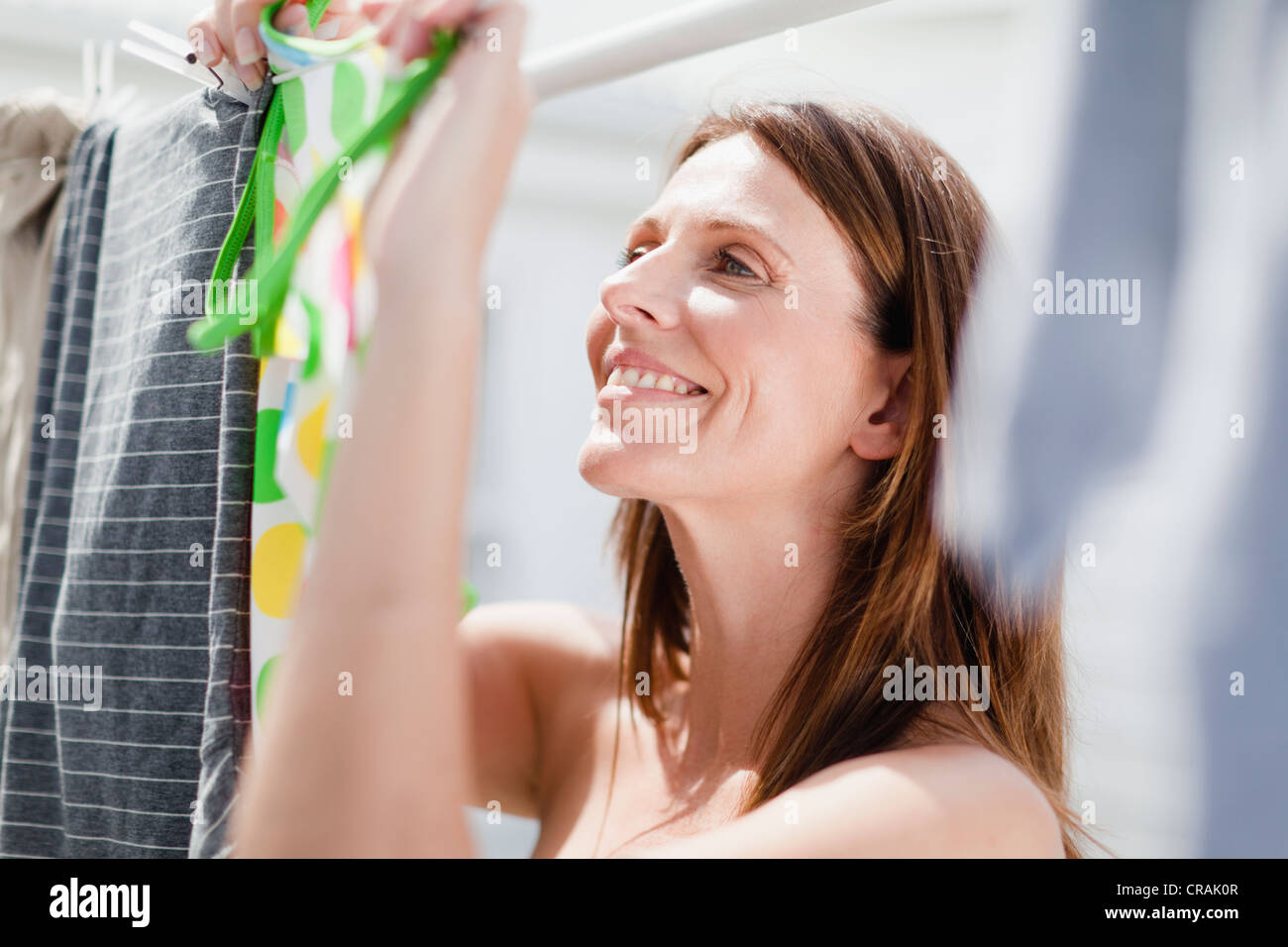 Lächelnde Frau hängende Wäsche Stockfoto