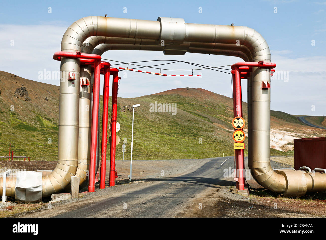 Straße unter einer Brücke der Rohre und Rohrleitungen mit heißem Wasser aus dem Kroefluvirkjun Geothermie-Kraftwerk, Geothermie Stockfoto