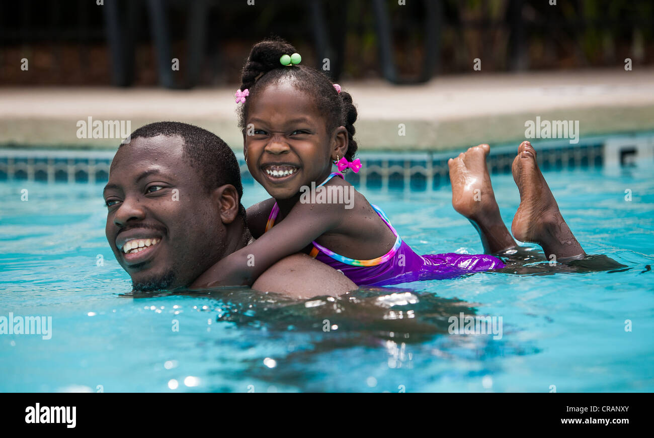 Vater und Tochter spielen in einem Schwimmbad. Stockfoto