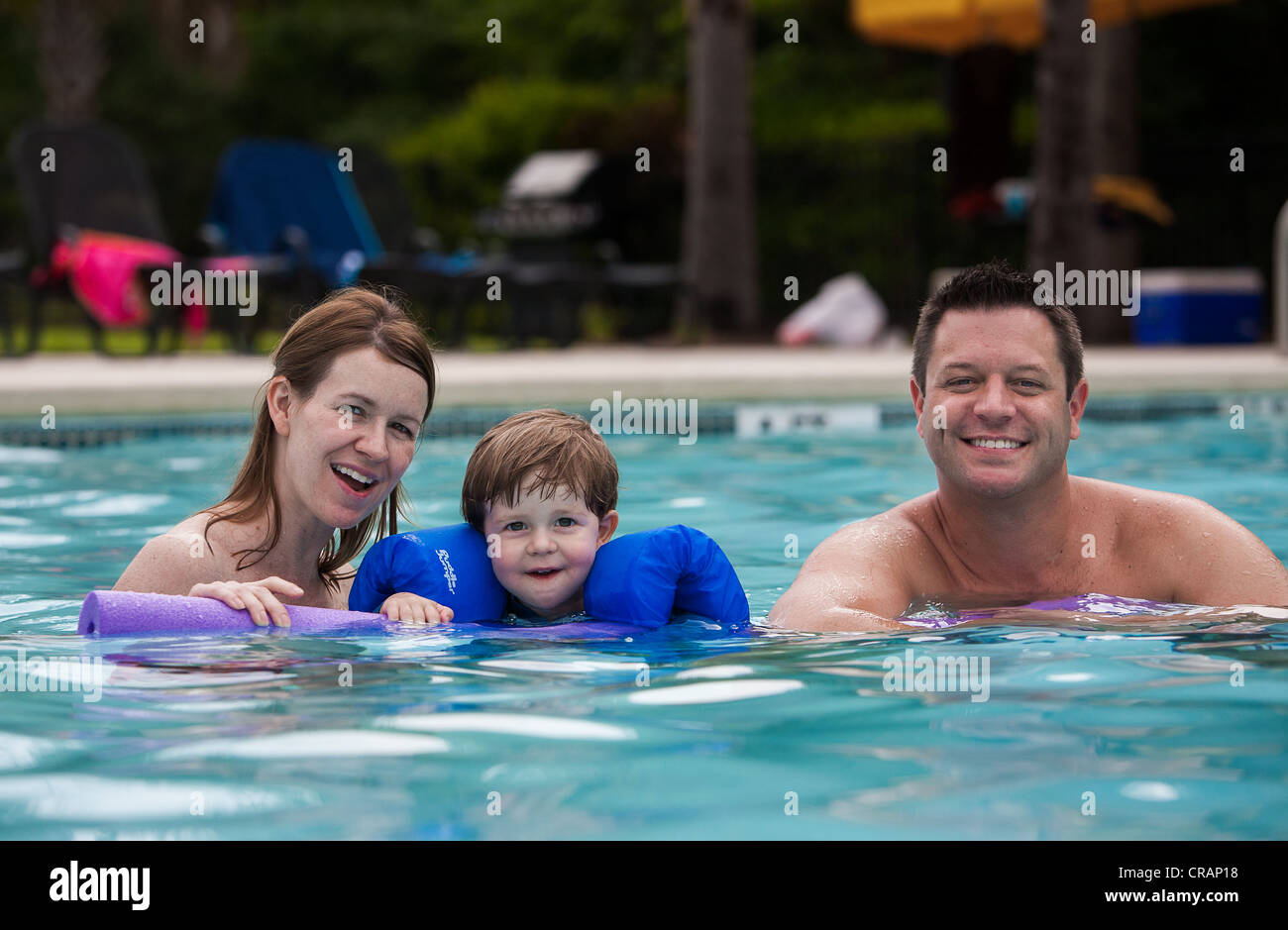 Vater, Mutter und Sohn das Schwimmbad genießen. Stockfoto