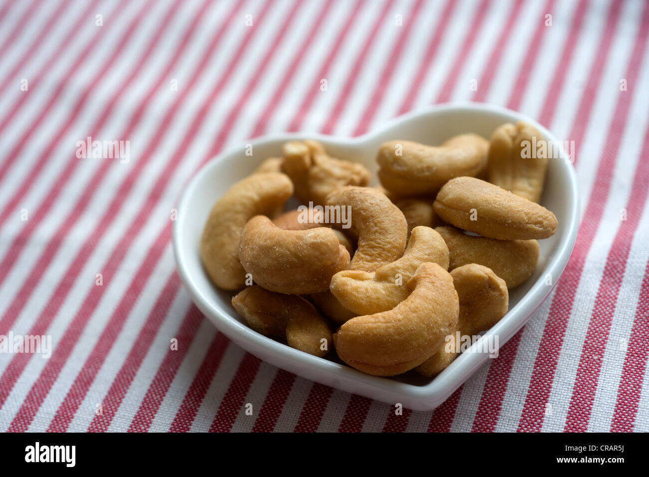 Geröstete Cashewkerne in eine Herzförmige Schale Stockfoto