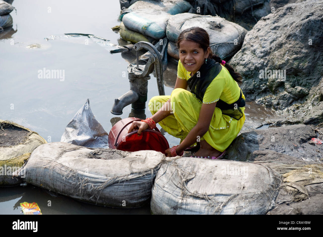 Junge Frau Wasserholen aus einem kontaminierten Teich Shibpur Bezirk, Howrah, Kalkutta, Westbengalen, Indien, Asien Stockfoto