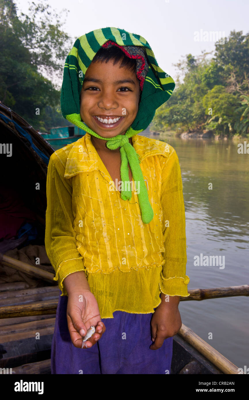 Freundliche Mädchen hält ein kleiner Fisch in ihrer Hand, Bangladesch, Asien Stockfoto