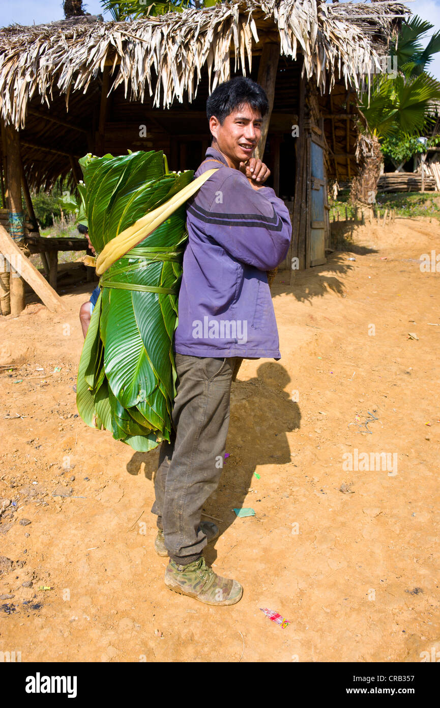 Mann mit Bambus verlässt Haus im traditionellen Dorf von Paia nahe entlang, Arunachal Pradesh, North East India, Indien, Asien Stockfoto