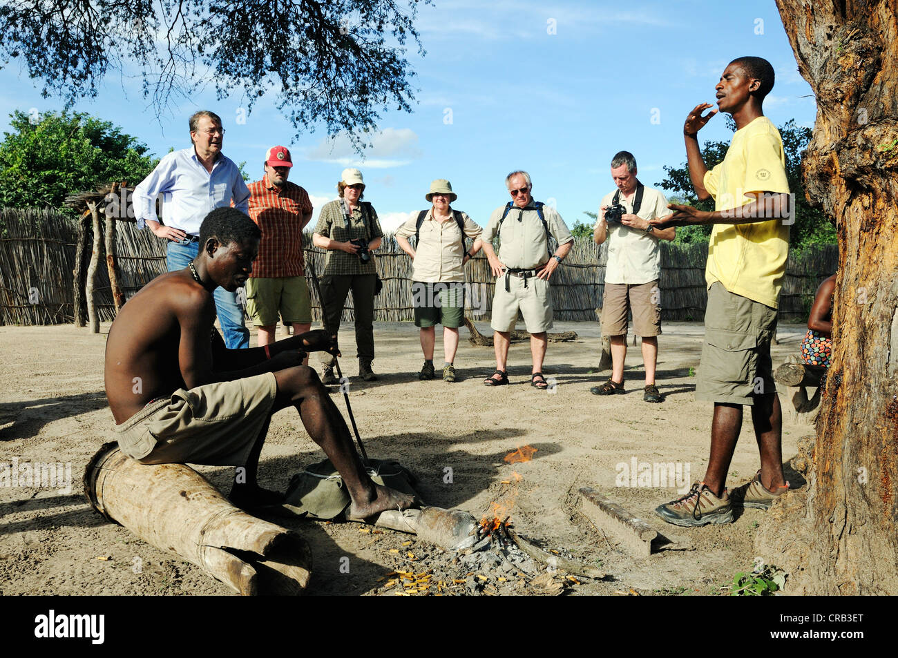 Reiseleiter und Touristen auf einer geführten Tour eines traditionellen Dorfes in der Nähe von Camp Kwando auf dem Kwando River Stockfoto