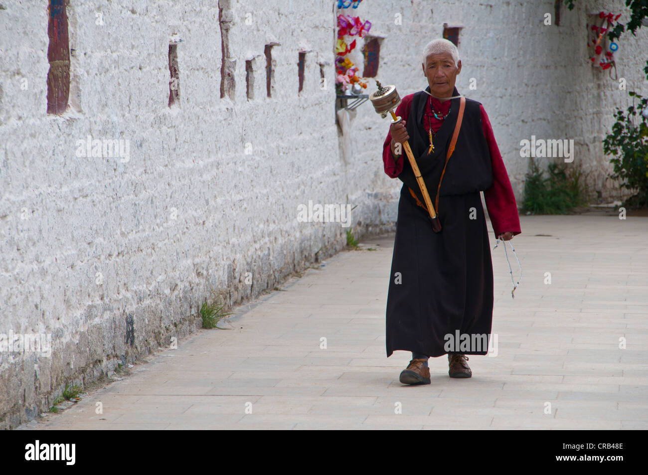 Pilger mit einer Gebetsmühle vor dem Potala-Palast, UNESCO-Weltkulturerbe, Lhasa, Tibet, Asien Stockfoto