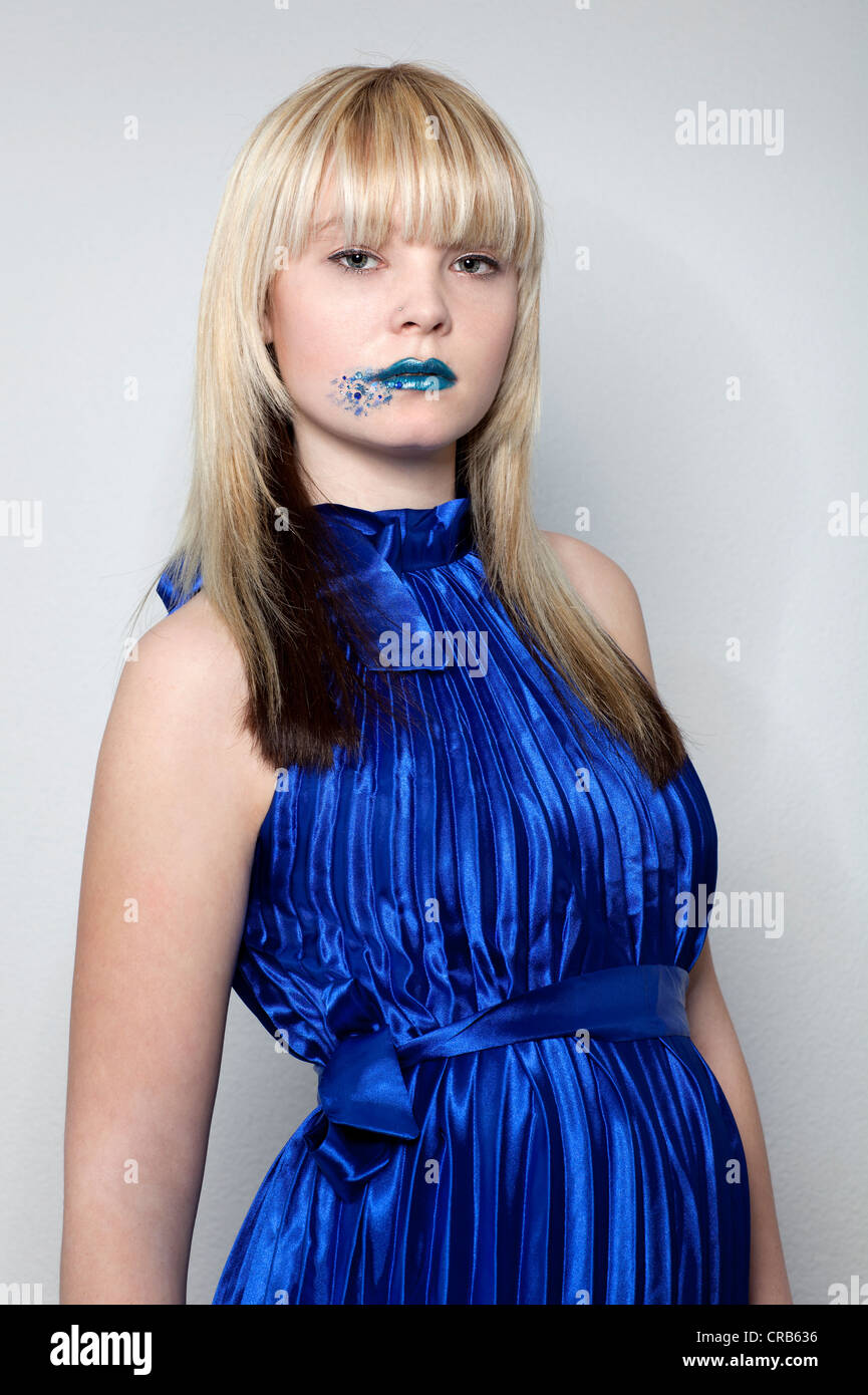 Junge, blonde Frau trägt ein blaues Kleid und blauen Lippenstift  Stockfotografie - Alamy
