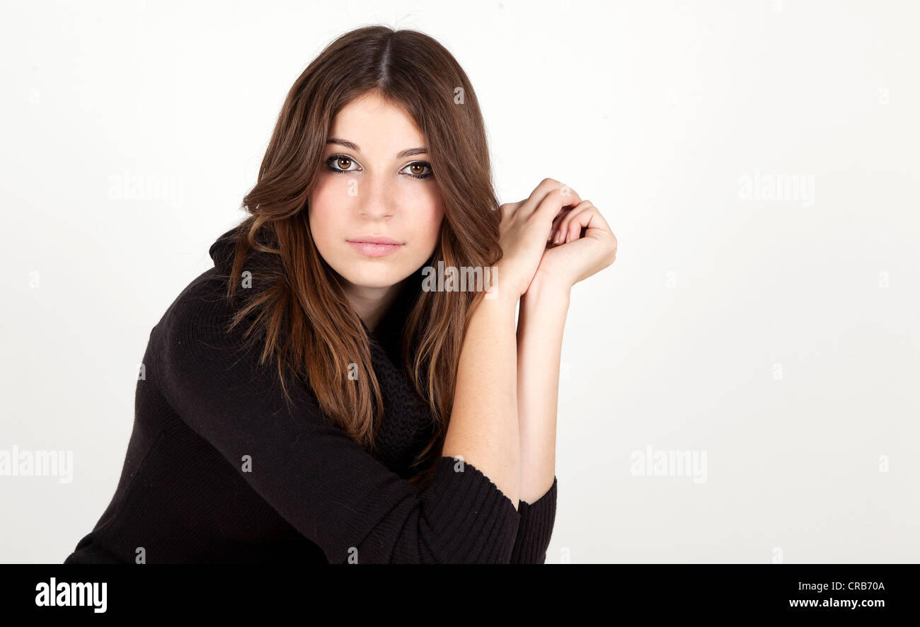 Junge Frau mit langen Haaren, trägt einen langen schwarzen Pullover, Porträt Stockfoto