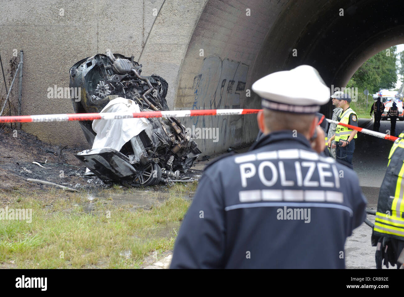 Wrack eines Audi Autos zerstört und ausgebrannt bis zur Unkenntlichkeit, nach einer heftigen Kollision gegen den Pfeiler einer Brücke Stockfoto