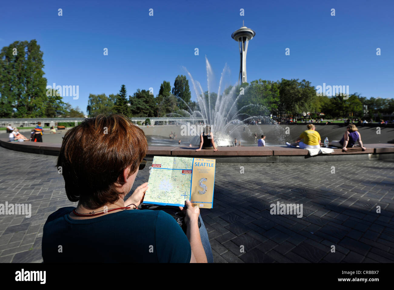 Frau hält einen Reiseführer von Seattle, International Brunnen vor der Space Needle, Seattle Center, Seattle Stockfoto