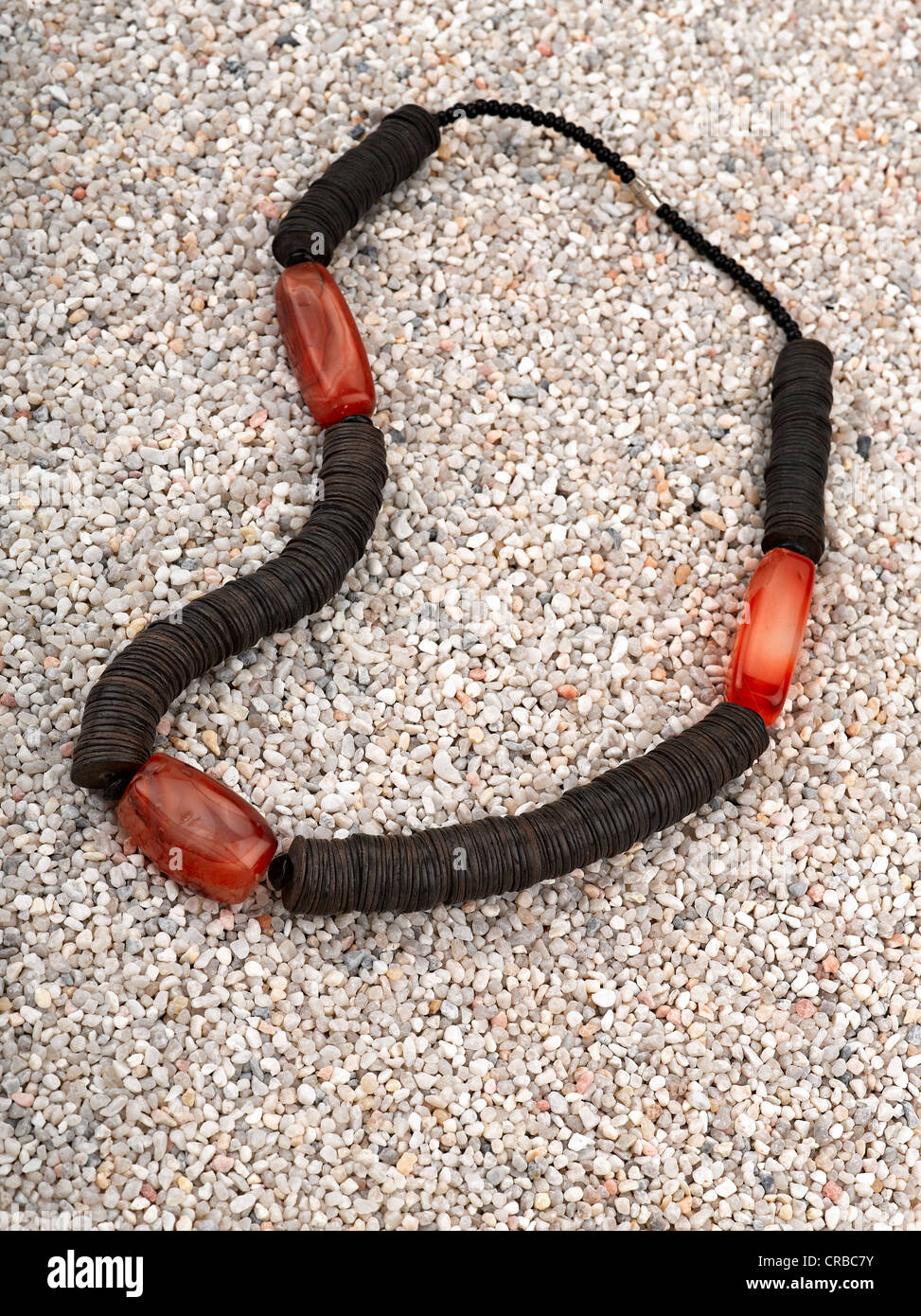 Ethnische Halskette mit Muscheln auf er Sand des Strandes. Stockfoto