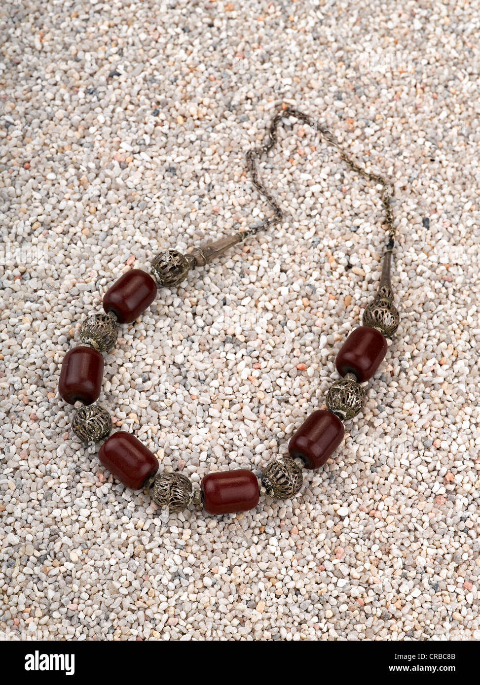 Ethnische Halskette mit Muscheln auf er Sand des Strandes. Stockfoto