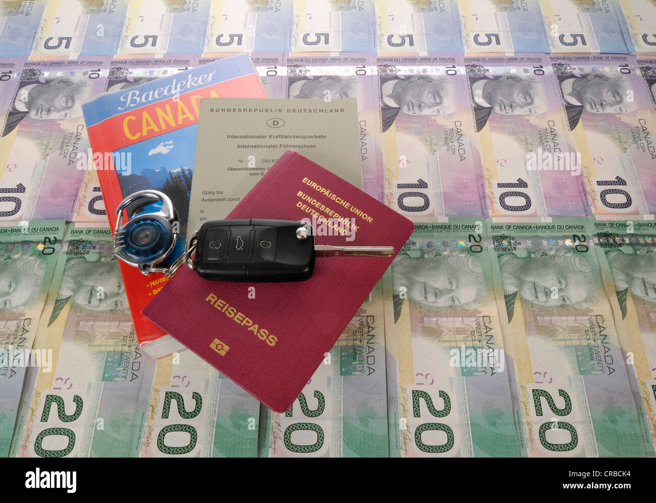 Zündschlüssel, internationaler Führerschein, Reisepass der Bundesrepublik Deutschland, Reiseführer für Kanada und verschiedenen Stockfoto