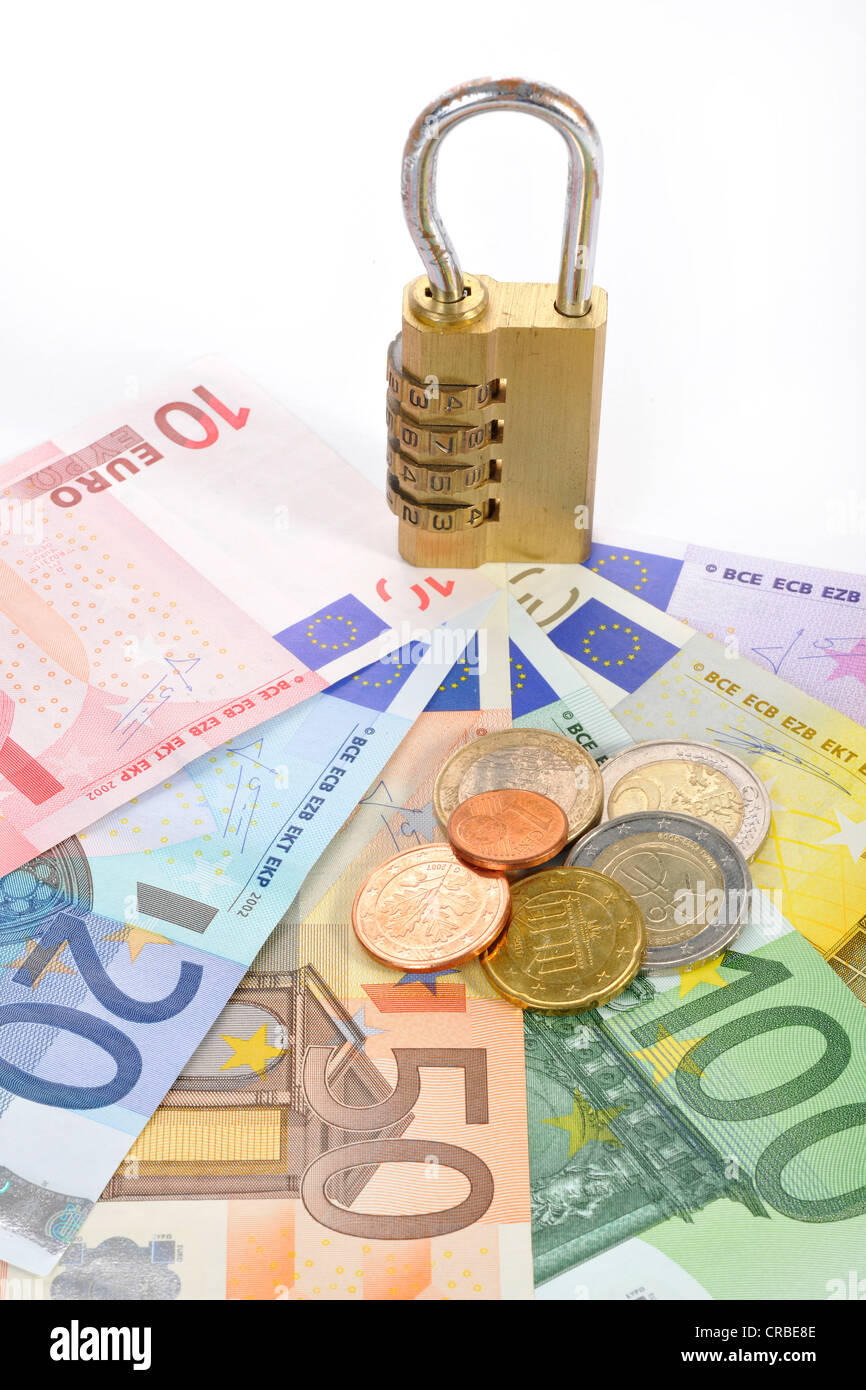 Zahlenschloss auf Euro-Banknoten und Münzen, symbolisches Bild der monetäre Sicherheit Stockfoto