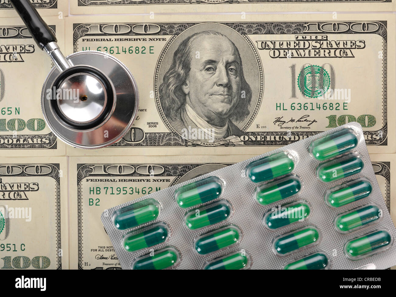 Stethoskop und Kapseln auf US-Dollar-Banknoten, symbolisches Bild einer Kranken US-Währung oder die steigenden Kosten des Gesundheitswesens Stockfoto
