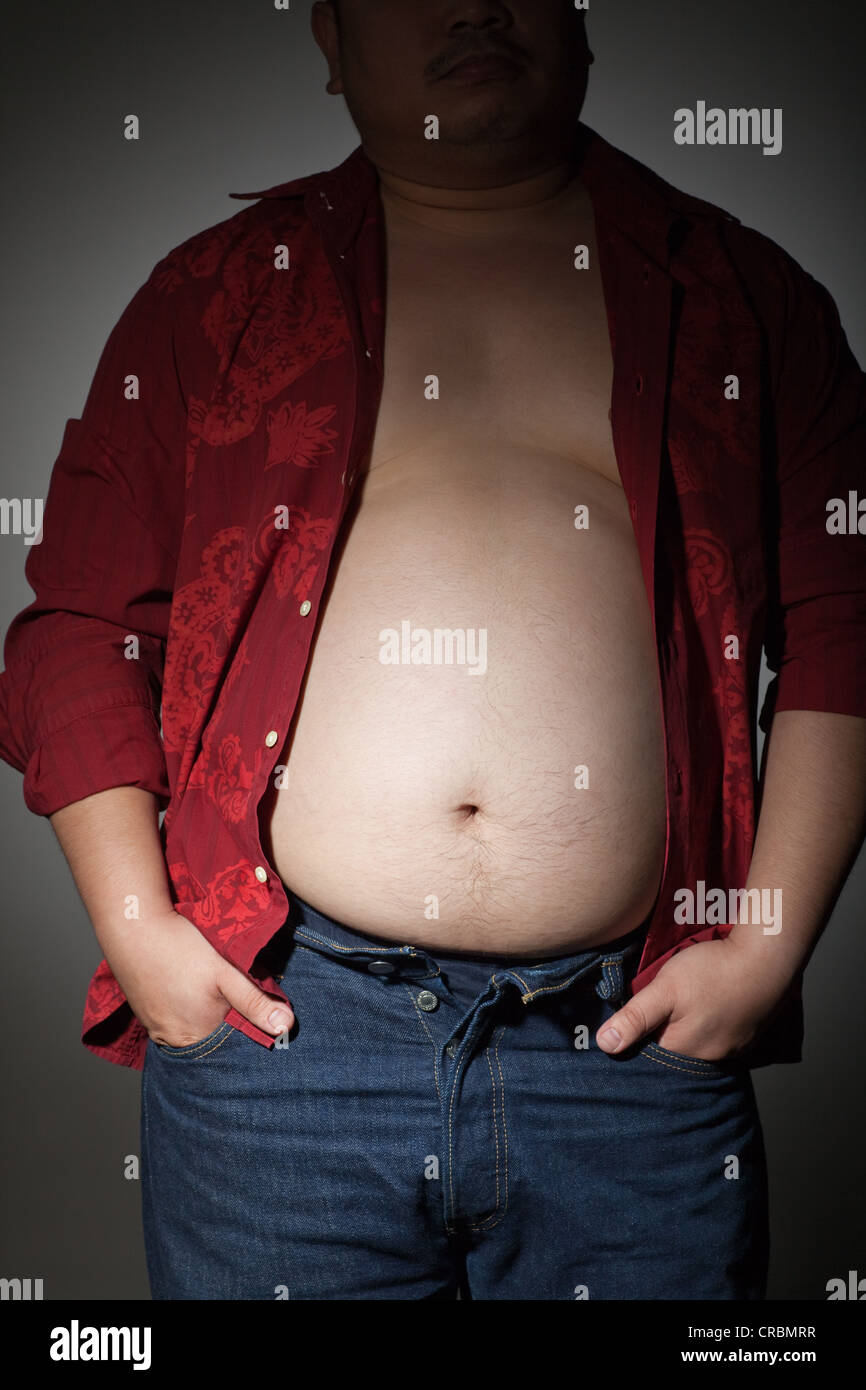 Dicker Mann mit Hemd aufgeknöpft und die Hände in den Taschen Stockfoto