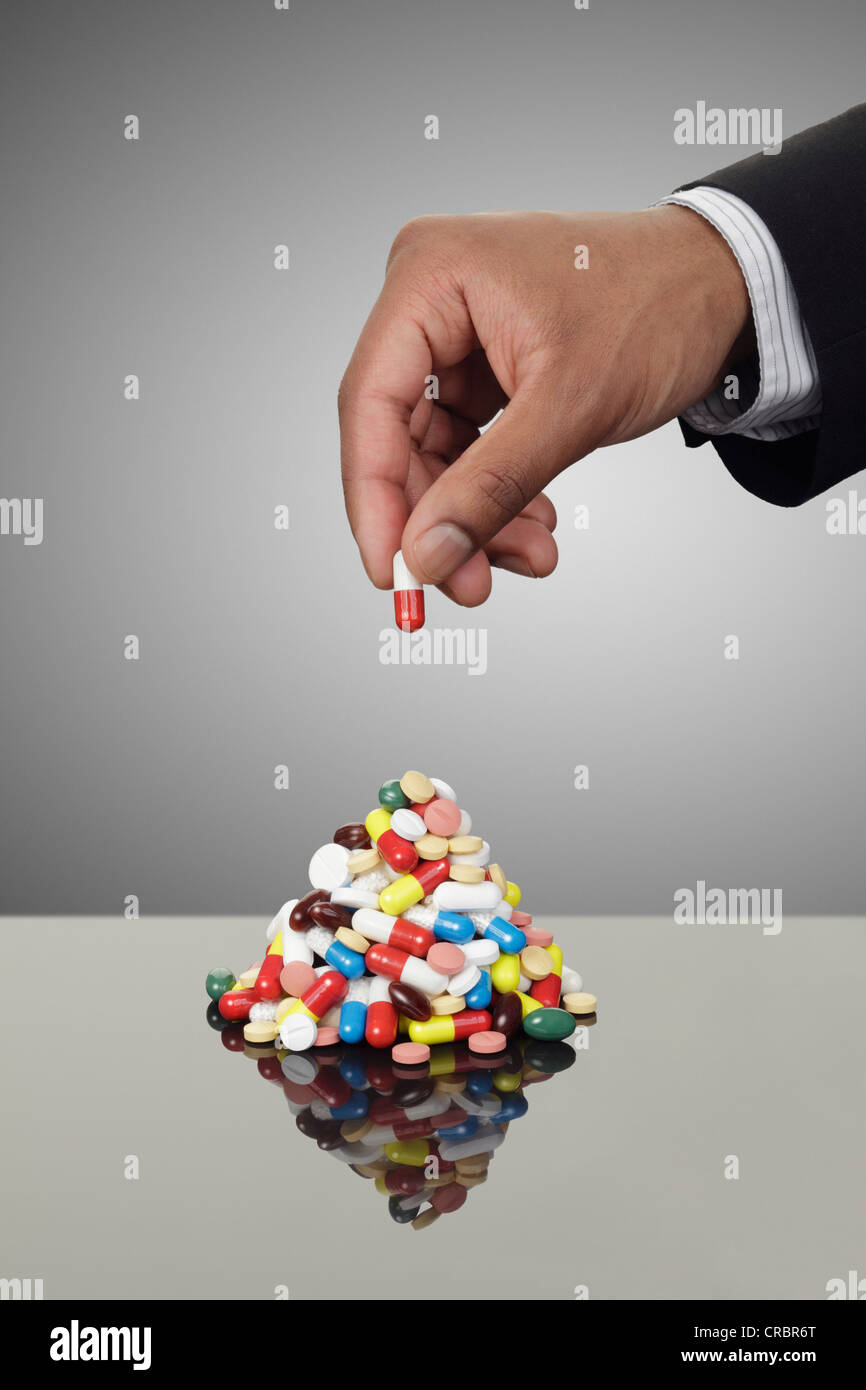 Geschäftsmann Stapeln Pillen auf Zähler Stockfoto