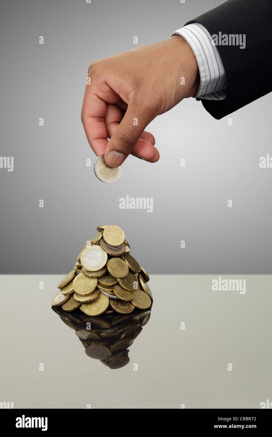 Geschäftsmann Stapeln Euro-Münzen Stockfoto
