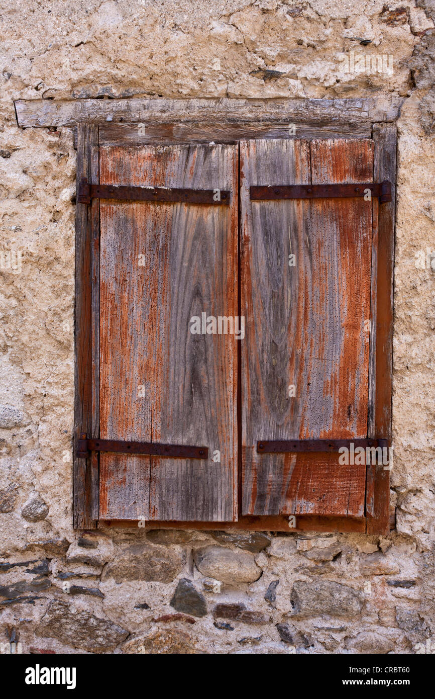 Ein Holzfenster Auslöser festgelegt in einer alten Mauer in das Dorf von Prats-de-Mollo-la-Preste, Languedoc-Roussillon, Frankreich Stockfoto