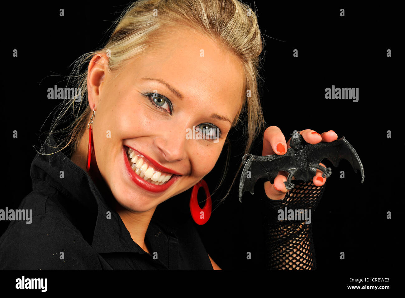 Junge Frau, Vamp, hält eine Kautschuk-Fledermaus Halloween Stockfoto