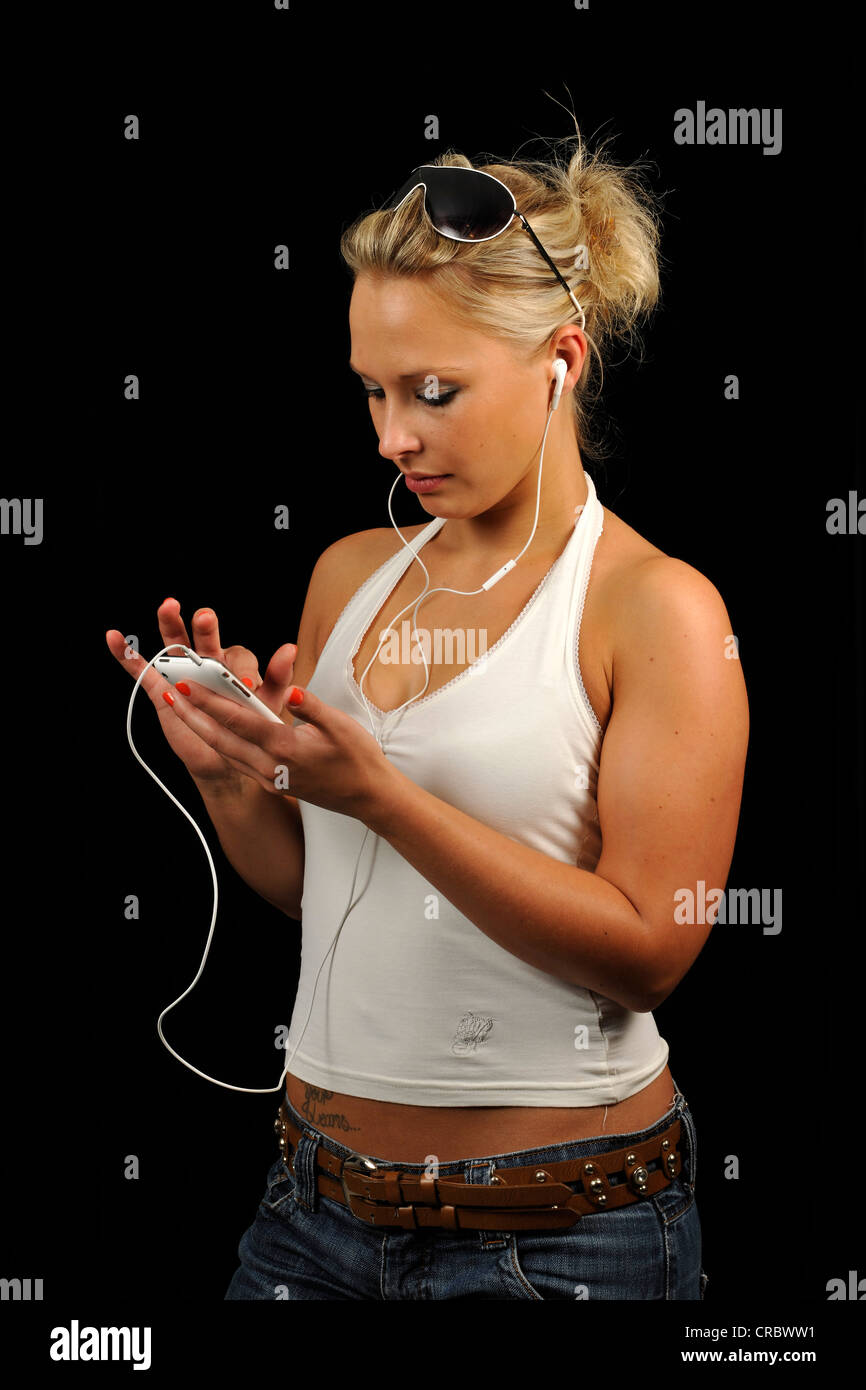 Junge Frau Betrieb einen weiße Apple iPhone, Musik hören, Kopfhörer, Kopfhörer Stockfoto