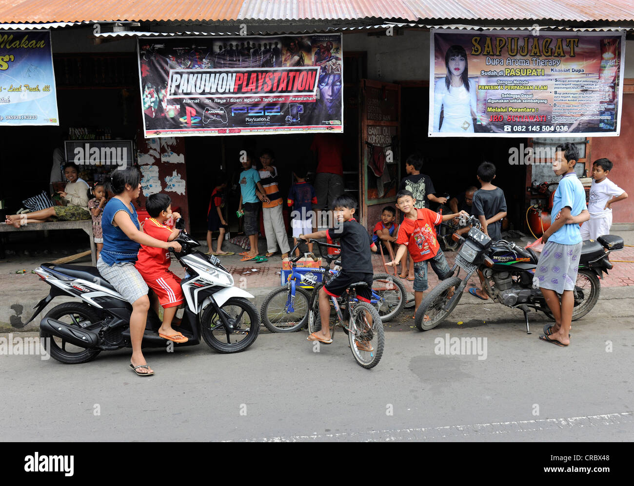 Frau und Kinder auf Fahrrädern, Tenganan, Bali, Indonesien, Südostasien Stockfoto