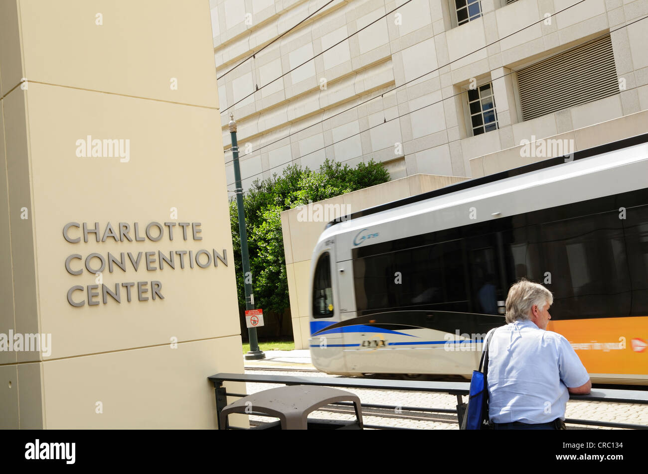 Ein Mann steht vor dem Charlotte Convention Center schaut zu, wie der Lynx Stadtbahn Zug für South Charlotte fährt. Stockfoto