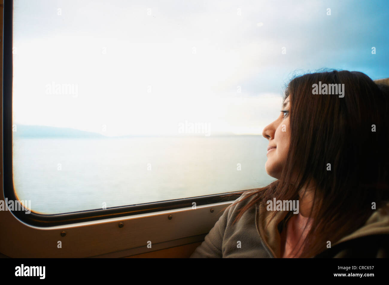 Frau schaut aus dem Zugfenster Stockfoto