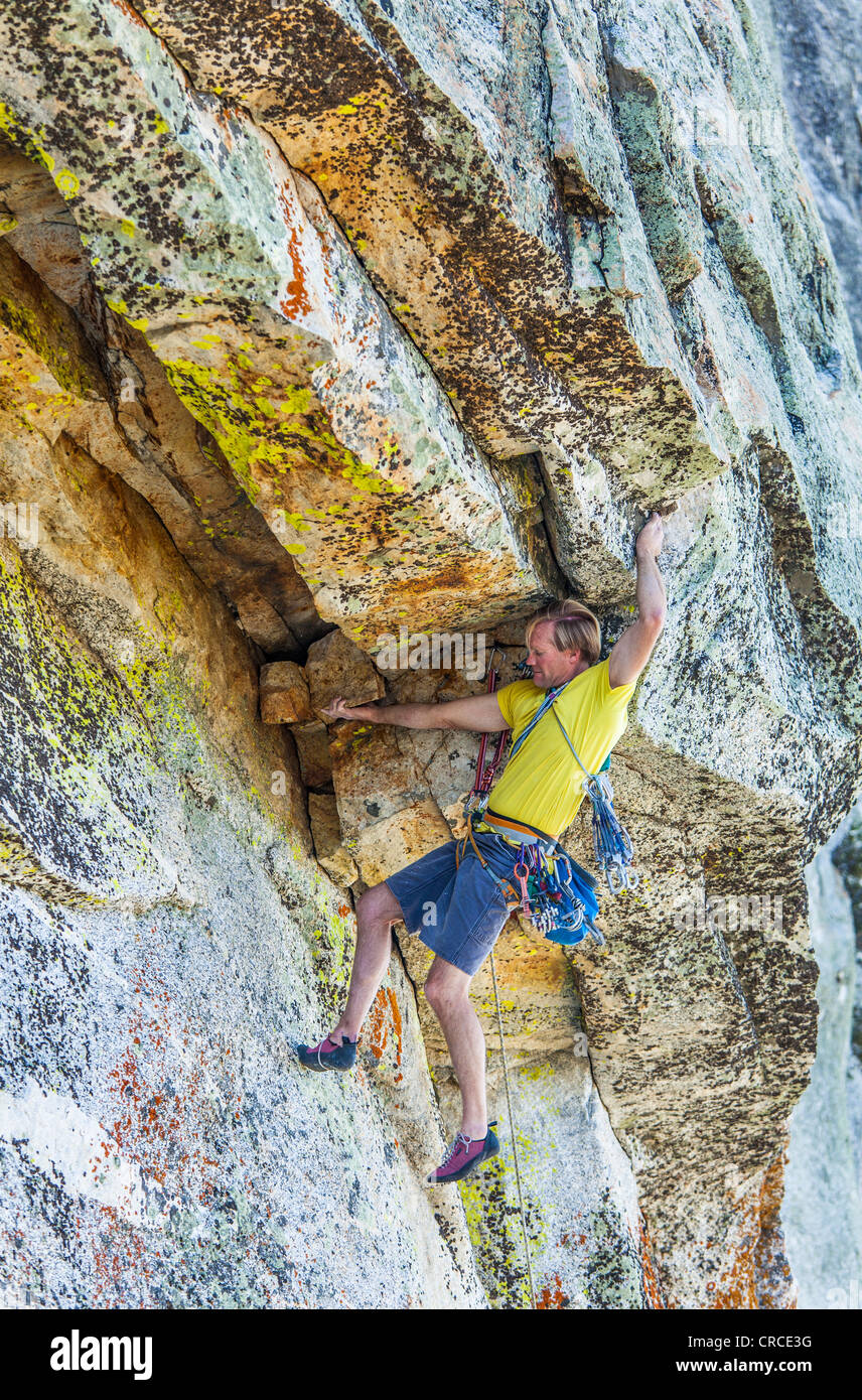 Männliche Felsen Kletterer kämpft für seinen nächsten Griff auf einem anspruchsvollen Aufstieg. Stockfoto