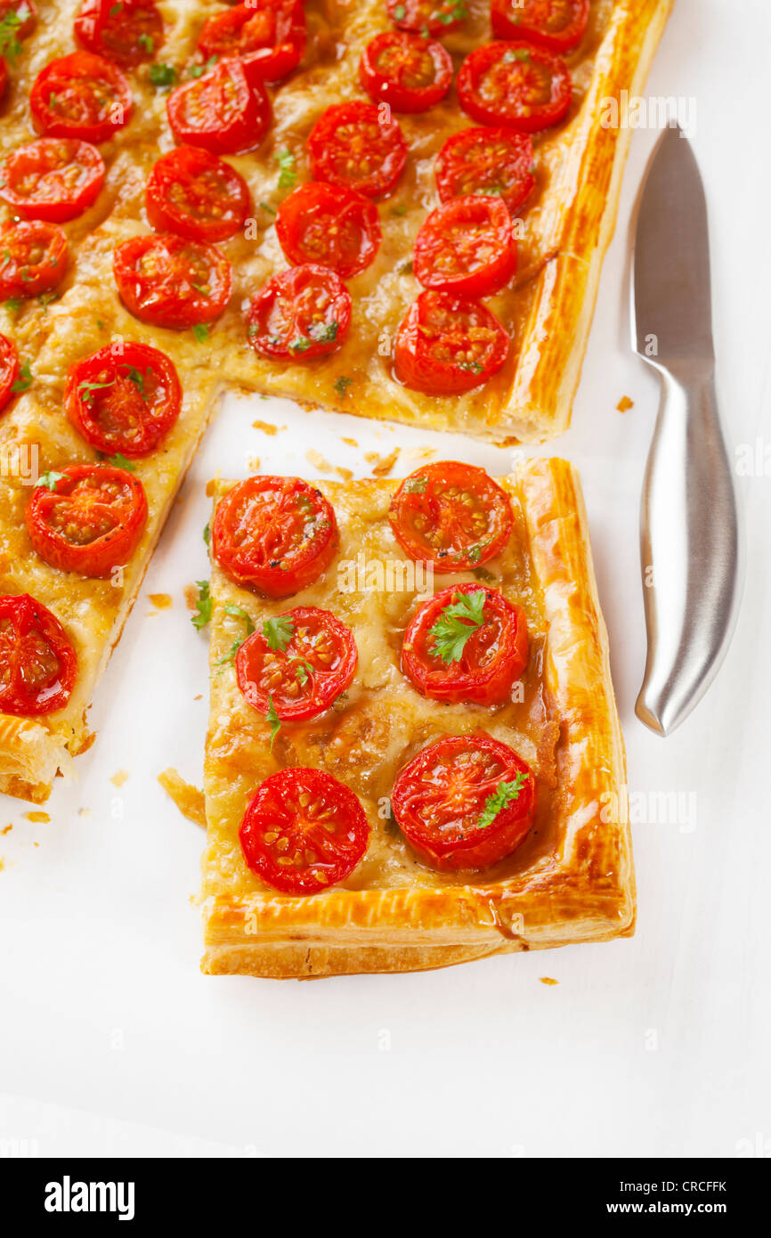 Tomaten Torte, Blätterteig mit Senf, Käse und Kirsche Toamtoes gekrönt. Stockfoto