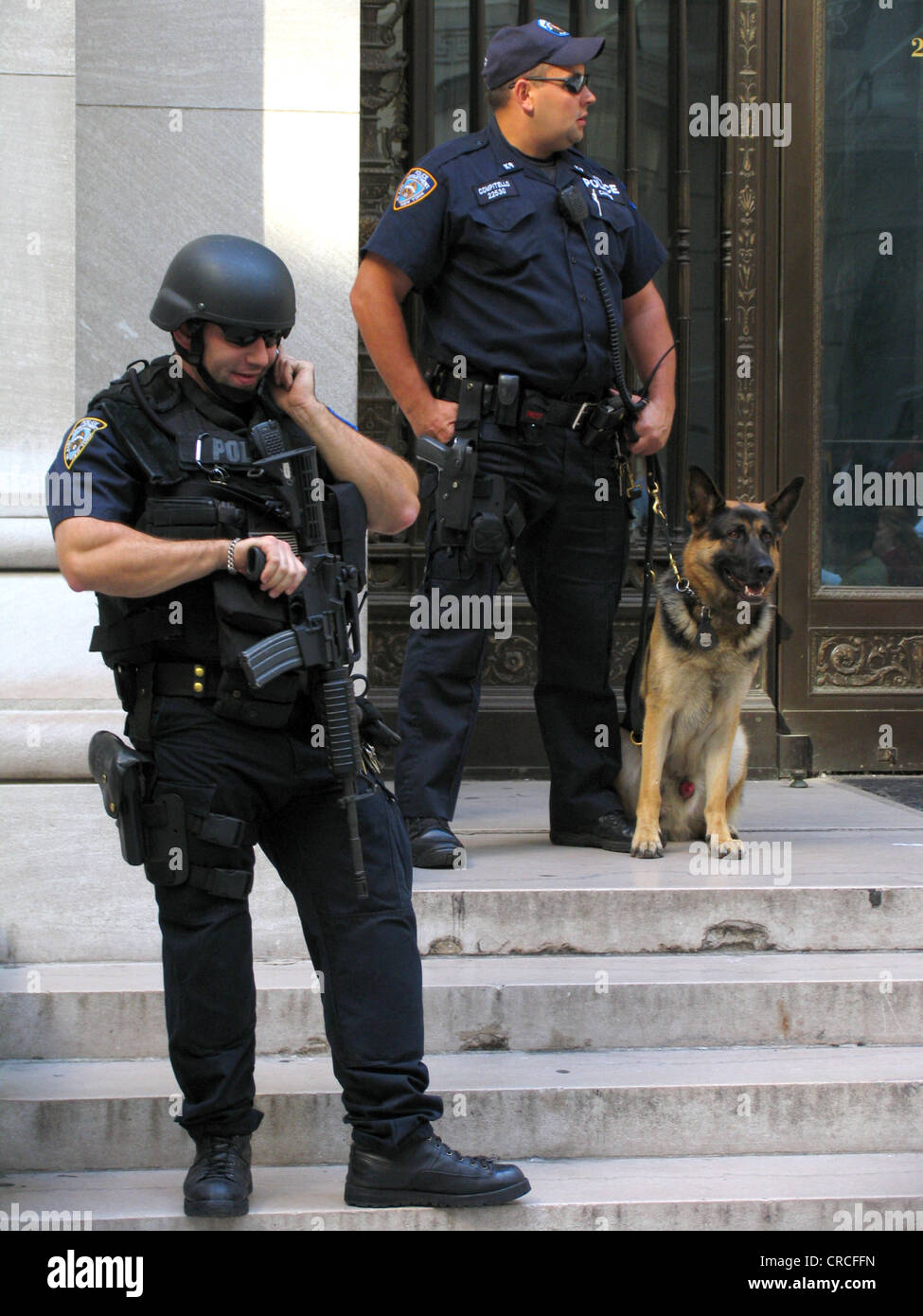 Schwer bewaffnete Polizisten mit Maschinengewehr und Polizeihund an New Yorker Börse Terceira an Wall Street, USA, New York City, Manhattan Stockfoto