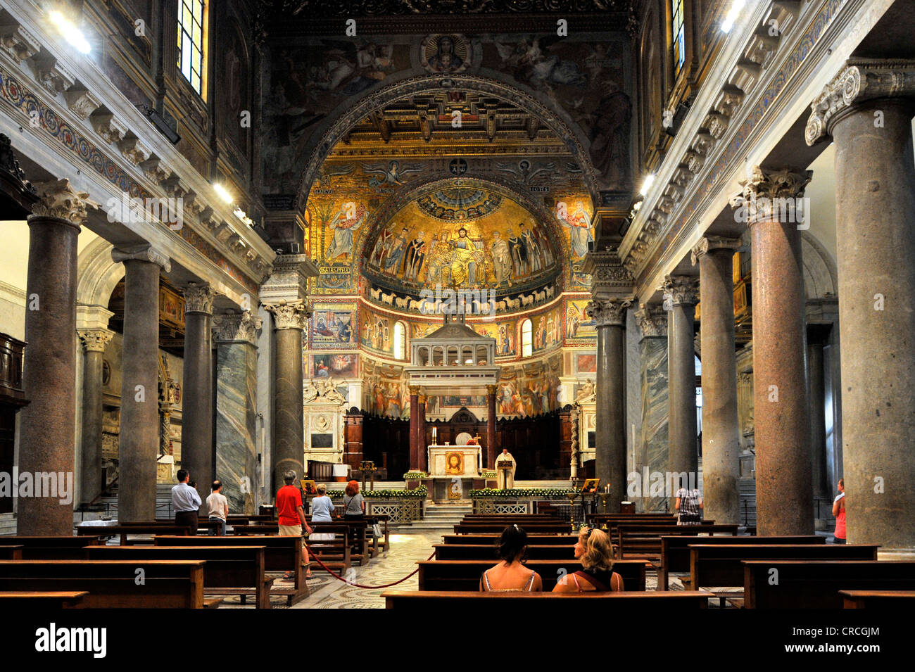 Kirchenschiff mit antiken ionischen Säulen, Triumphbogen, der Altar mit Marmor Ziborium oder Baldachin und Apsis während der Messe, Basilika Santa Maria Stockfoto