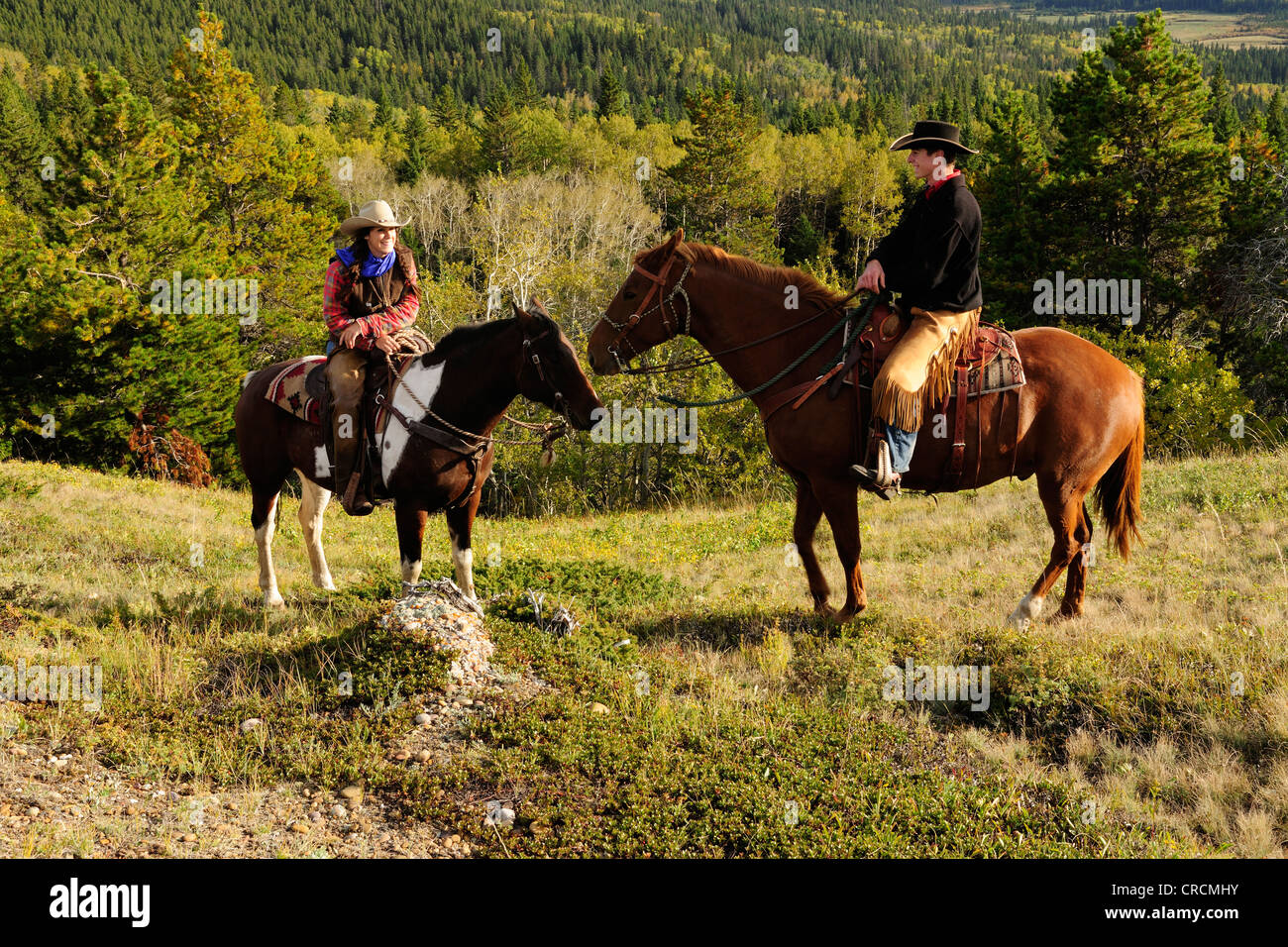 Ein Cowgirl und ein Cowboy sitzt auf ihre Pferde, Saskatchewan, Kanada Stockfoto