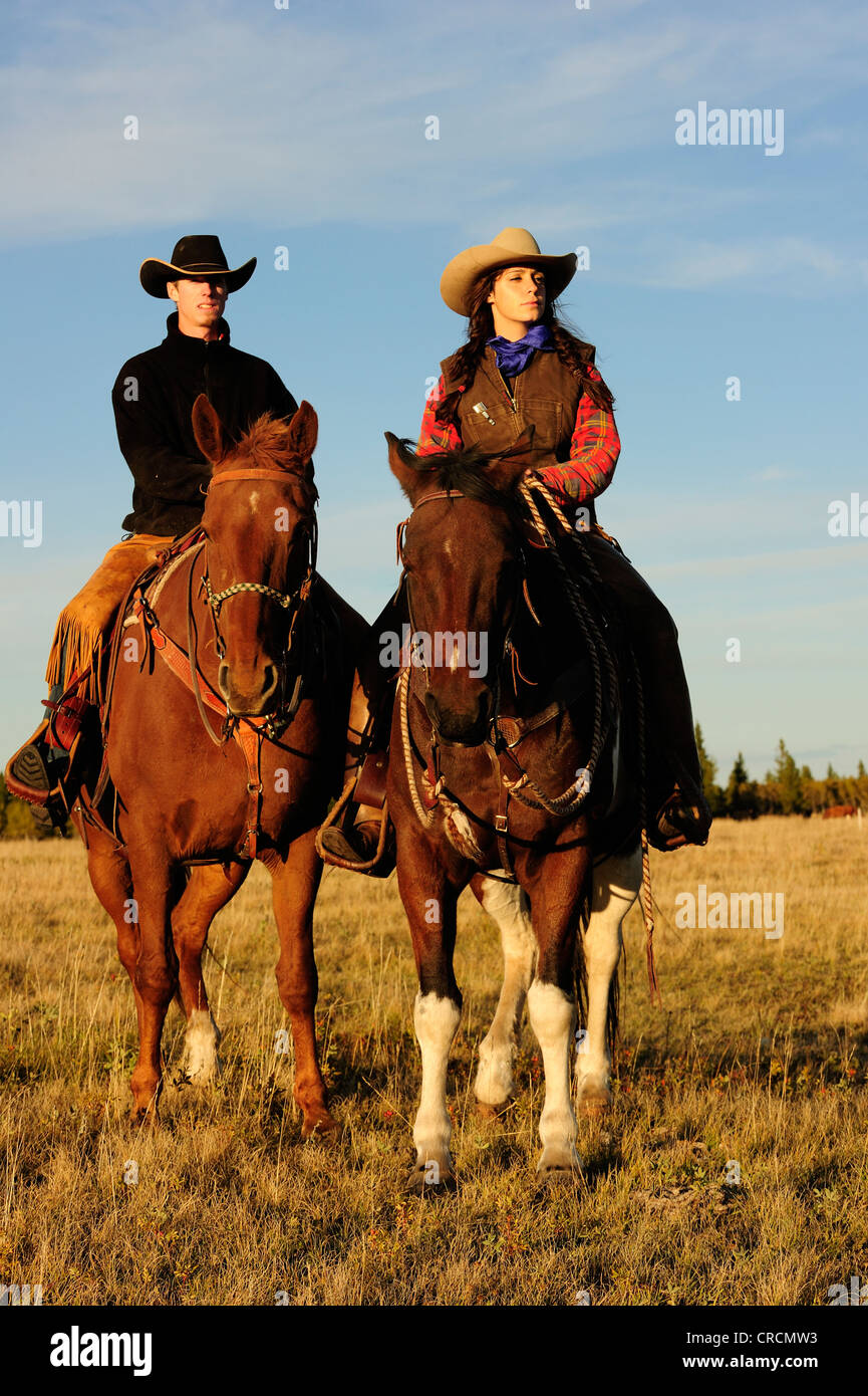 Cowboy und Cowgirl reiten Pferde, Blick in die Ferne, Saskatchewan, Kanada, Nordamerika Stockfoto