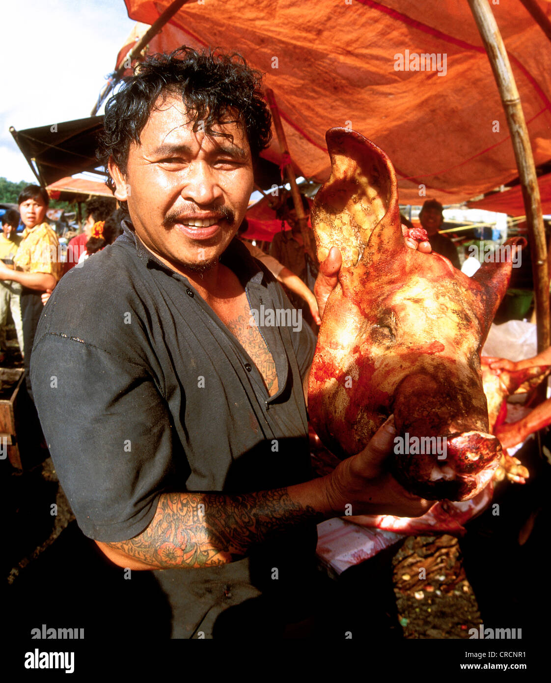 Samstag-Markt in dem Dorf Tomahon. Ein Metzger mit neu geschlachteten Schweinekopf, Indonesien, Sulawesi Stockfoto