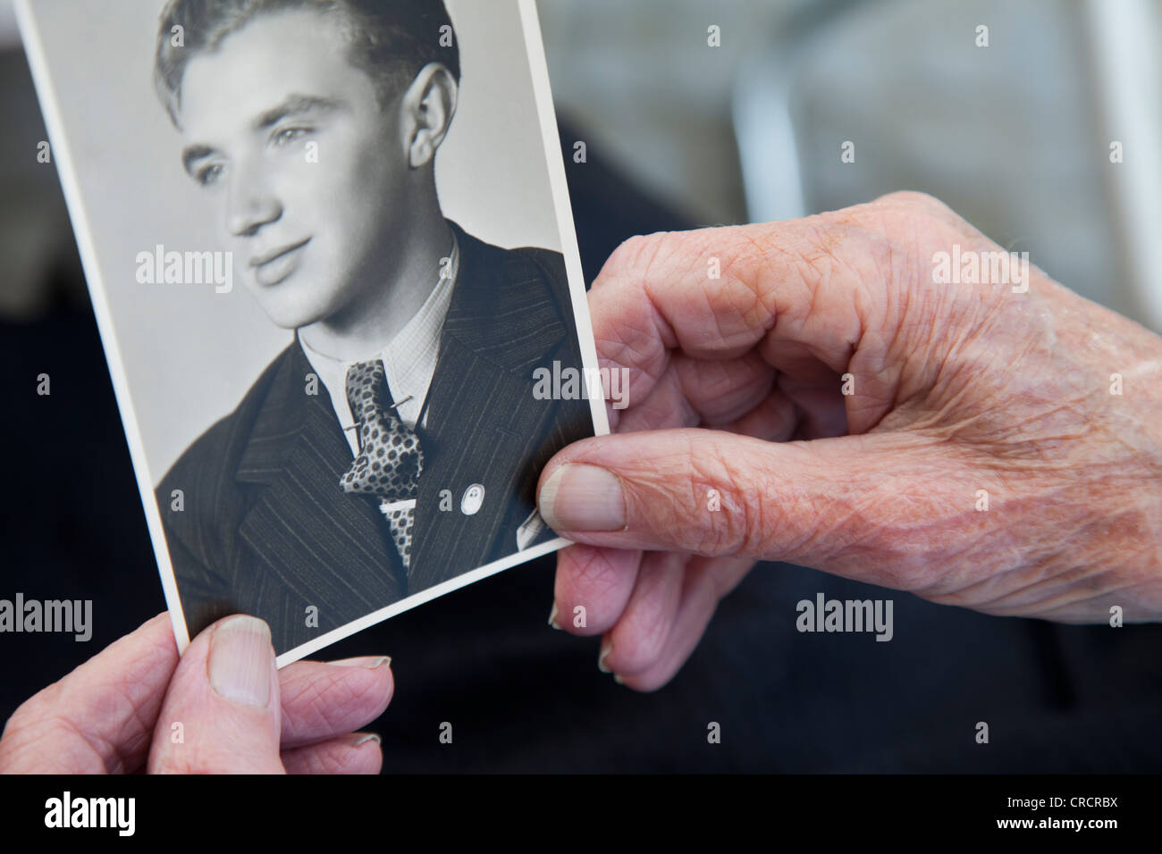 Betrachten ein altes Foto, alten Mannes Hand hält ein schwarz / weiß Fotografie, Erinnerungen, historisches Foto, Porträt, Pflegeheim Stockfoto