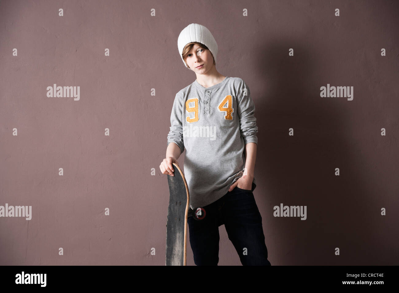 Teenager mit Wollmütze mit skateboard Stockfoto